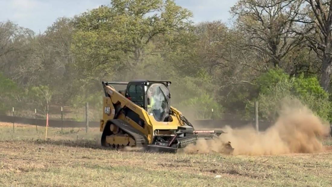 Compact track loader mulching a field